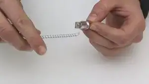 Rethread the shock cord through the segment. Tie the end of the shock cord to the pin and thread the other end through the pole.