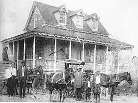 Horses and wagons in front of the house