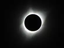 An image of a total solar eclipse at Orin Junction, Wyoming in 2017. A total solar eclipse happens when the Moon completely blocks the face of the Sun.  It is the result of a cosmic coincidence. Even though the Sun is about 400 times bigger than the Moon, it is also about 400 times farther away. This makes the Sun and the Moon appear almost exactly the same size in our sky.